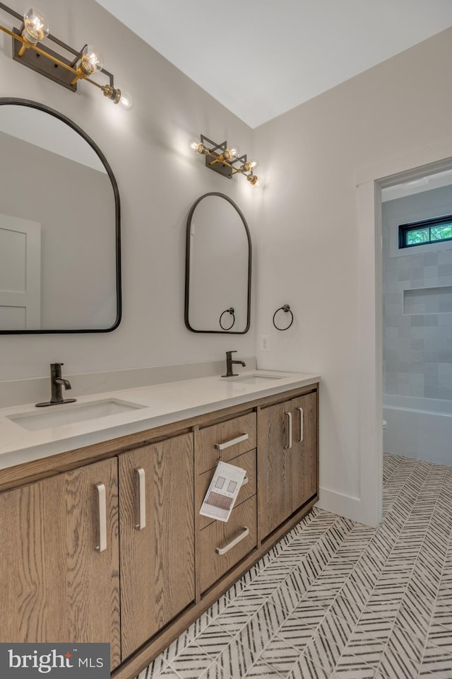 bathroom featuring dual vanity and tiled shower / bath