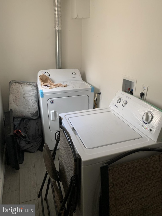 clothes washing area with washer hookup, tile flooring, and washer and clothes dryer