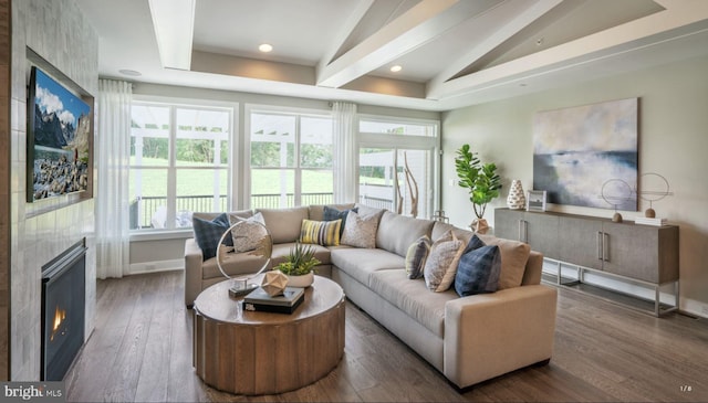 living room with a large fireplace, vaulted ceiling, and dark hardwood / wood-style floors