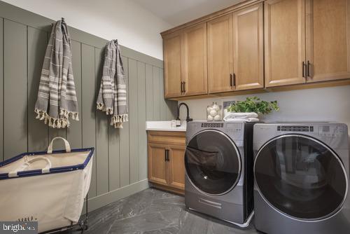 washroom featuring sink, cabinets, washer and clothes dryer, and dark tile floors