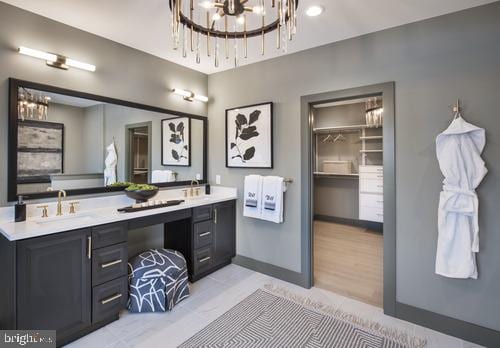 bathroom featuring an inviting chandelier, double sink, vanity with extensive cabinet space, and hardwood / wood-style flooring