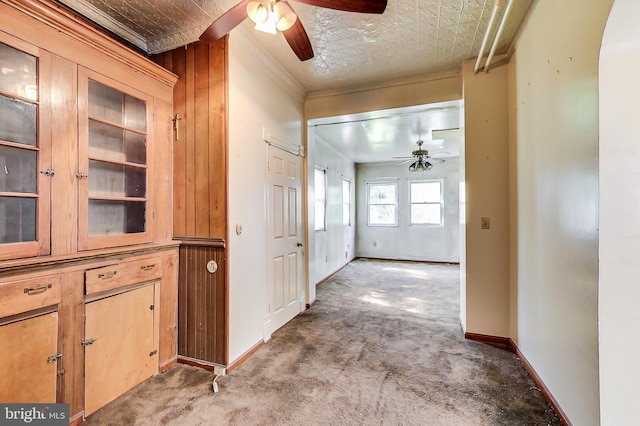 corridor featuring built in features, carpet floors, and ornamental molding