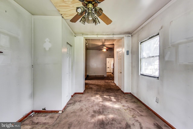 empty room featuring ceiling fan and dark carpet