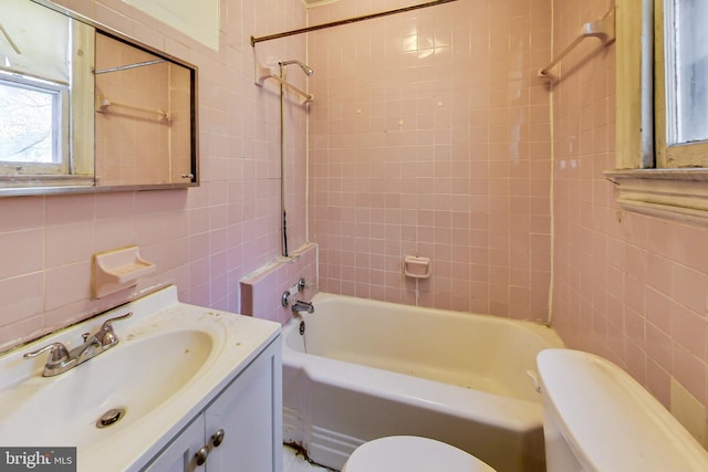 full bathroom featuring tiled shower / bath combo, tile walls, toilet, tasteful backsplash, and large vanity