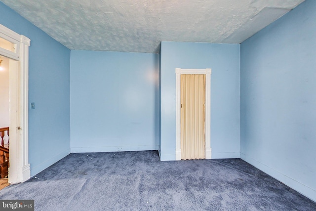 carpeted spare room featuring a textured ceiling