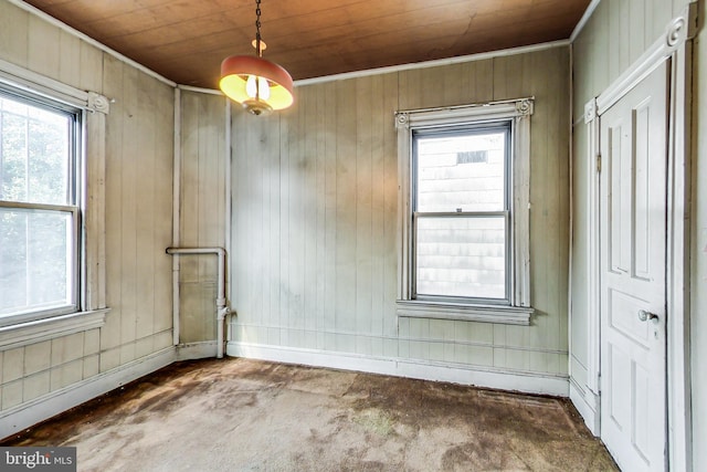 unfurnished room with wood walls, wooden ceiling, and dark colored carpet