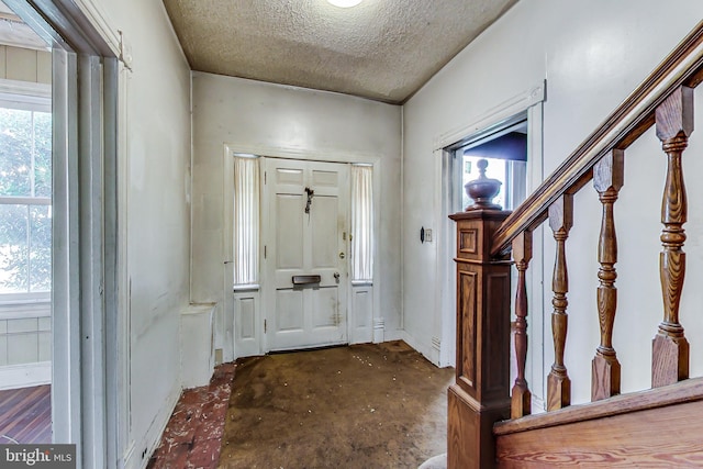 foyer entrance with a textured ceiling and dark hardwood / wood-style flooring