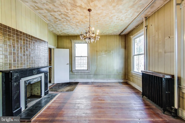 unfurnished living room featuring dark hardwood / wood-style flooring and a notable chandelier