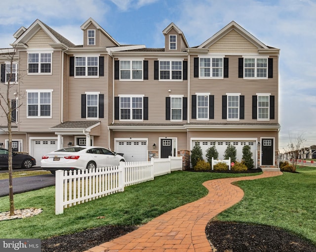 townhome / multi-family property featuring a front lawn and a garage