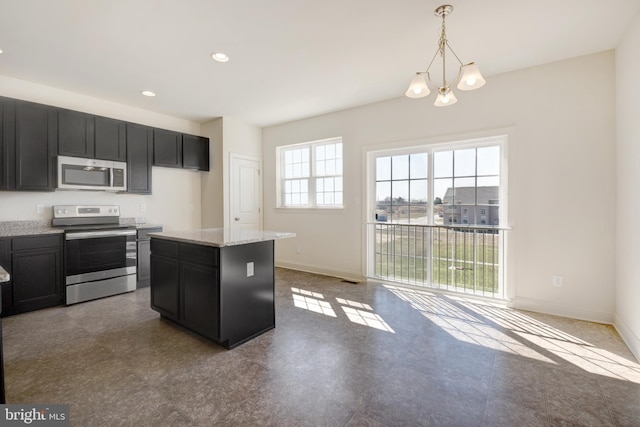 kitchen featuring an inviting chandelier, appliances with stainless steel finishes, a center island, light stone countertops, and hanging light fixtures