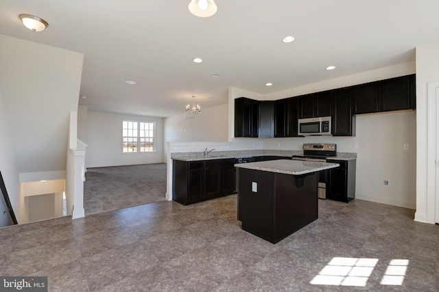 kitchen with a chandelier, stainless steel appliances, light tile flooring, light stone countertops, and sink