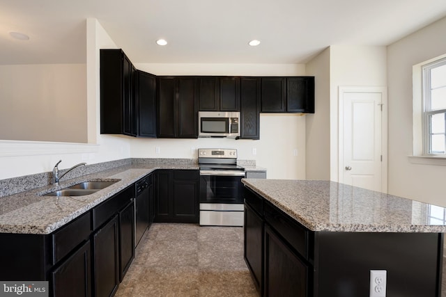 kitchen featuring light tile floors, sink, light stone counters, and stainless steel appliances