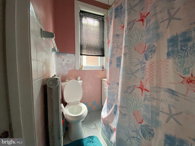 bathroom with tile walls, a shower with shower curtain, and toilet