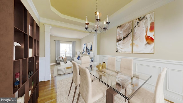 dining room with an inviting chandelier, hardwood / wood-style floors, and a tray ceiling