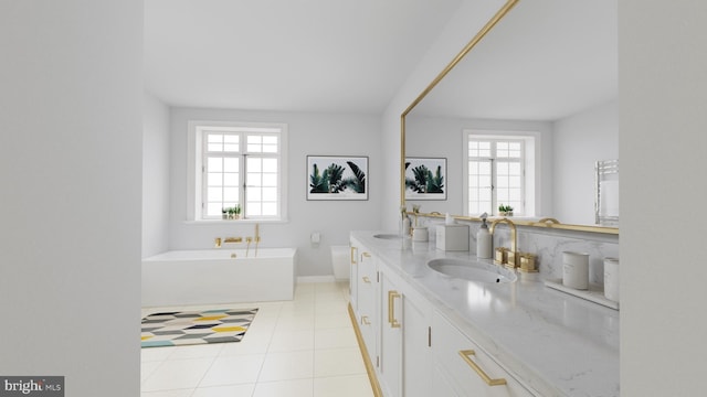 bathroom featuring a bathtub, tile floors, a wealth of natural light, and double vanity