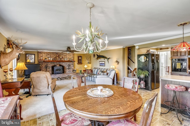 tiled dining space featuring a fireplace, brick wall, ceiling fan with notable chandelier, and ornamental molding