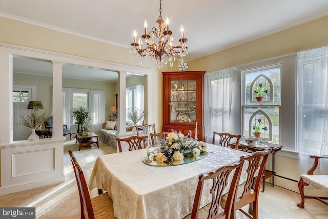 carpeted dining area featuring ornamental molding, a chandelier, and ornate columns