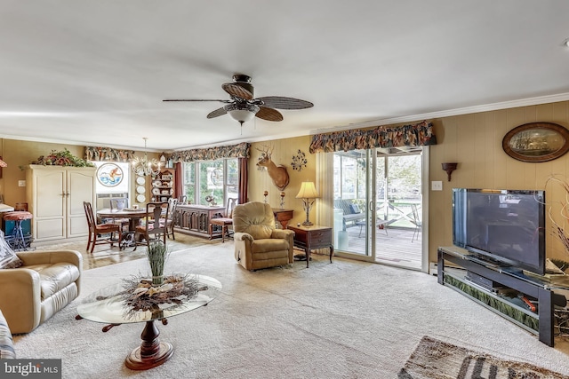 carpeted living room with crown molding and ceiling fan with notable chandelier