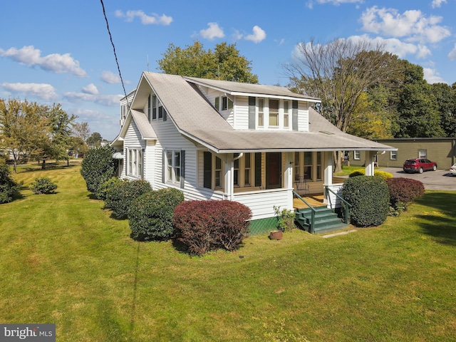 rear view of house with a lawn and a porch