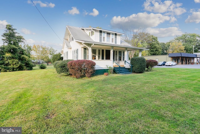 view of front facade featuring covered porch and a front yard