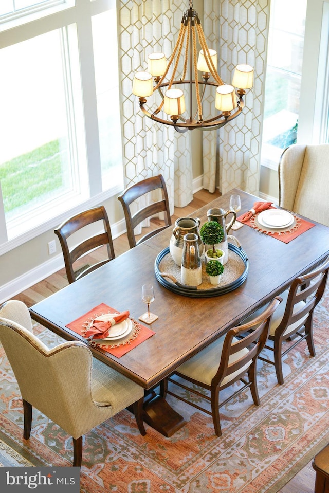 dining room with light hardwood / wood-style flooring, an inviting chandelier, and plenty of natural light