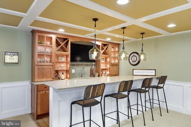 bar with coffered ceiling, decorative light fixtures, sink, light stone countertops, and light carpet