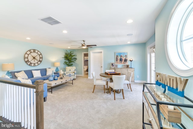 carpeted living room with ceiling fan