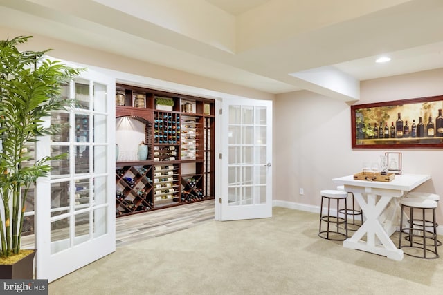 wine room with french doors and light colored carpet