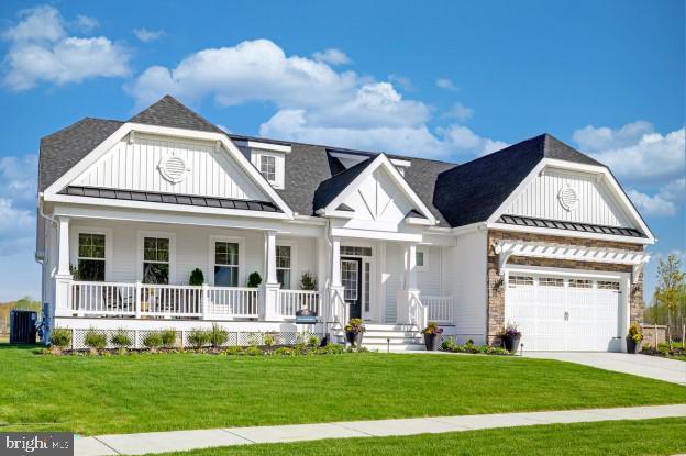 view of front of property with a porch, central AC, and a front lawn