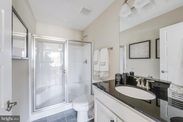 bathroom featuring oversized vanity, tile flooring, toilet, a shower with door, and ceiling fan