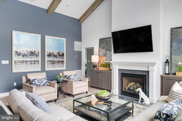 living room with light hardwood / wood-style flooring, beam ceiling, and high vaulted ceiling