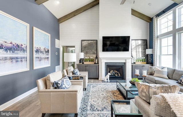 living room with high vaulted ceiling, beamed ceiling, and light hardwood / wood-style floors