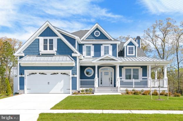 view of front facade with a front lawn, a porch, and a garage