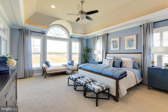 carpeted bedroom featuring ceiling fan, crown molding, and a raised ceiling