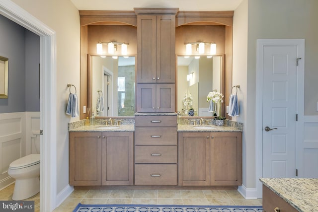 bathroom with toilet, tile floors, and dual vanity