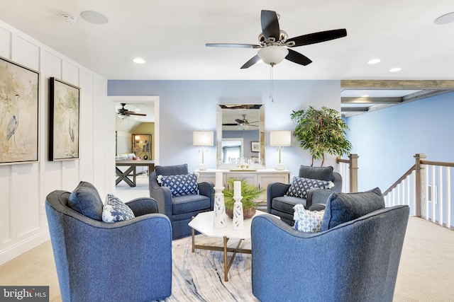 living room featuring beam ceiling, ceiling fan, and light carpet