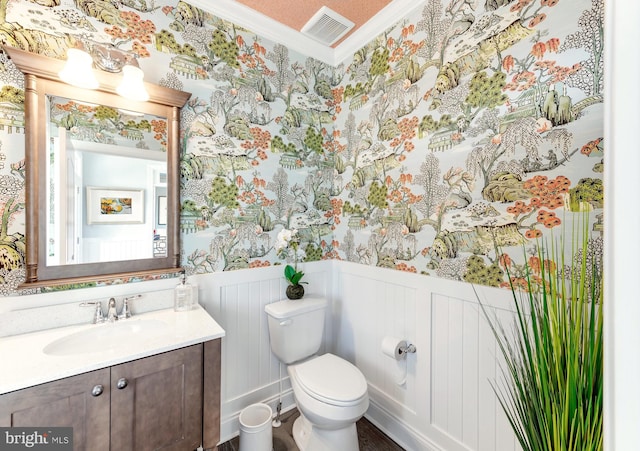 bathroom with toilet, ornamental molding, and vanity