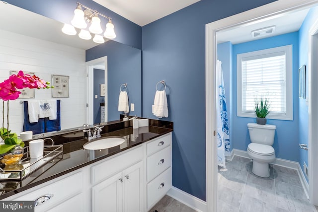 bathroom with large vanity, tile floors, toilet, and a notable chandelier