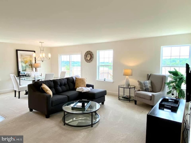 living room with light carpet and a chandelier