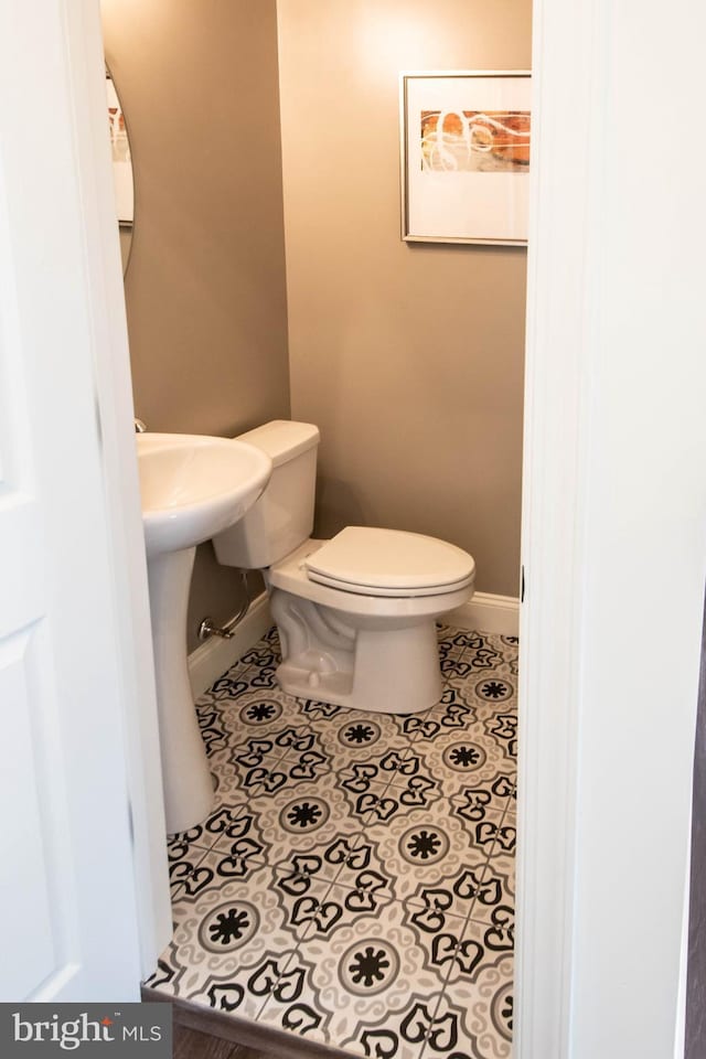 bathroom featuring tile flooring and toilet