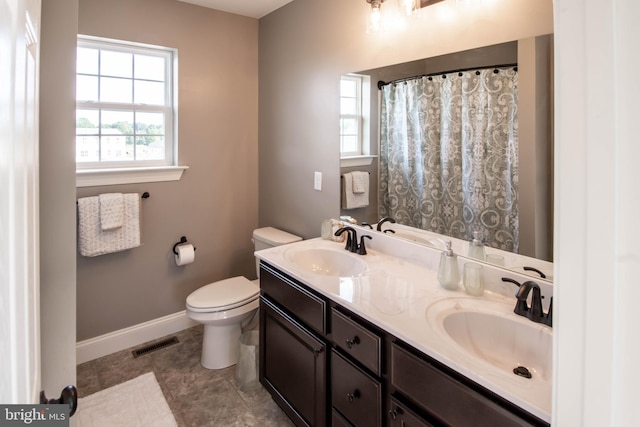 bathroom with double sink vanity, tile flooring, and toilet