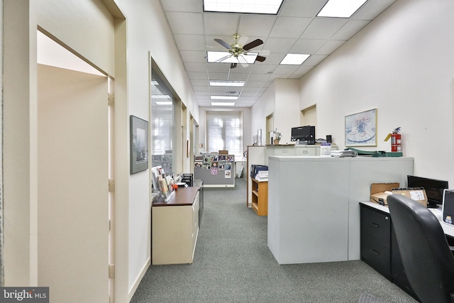 interior space featuring ceiling fan and a drop ceiling