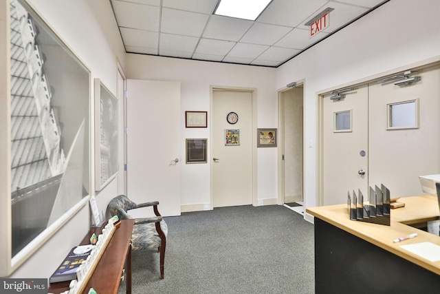 interior space featuring a paneled ceiling and dark carpet