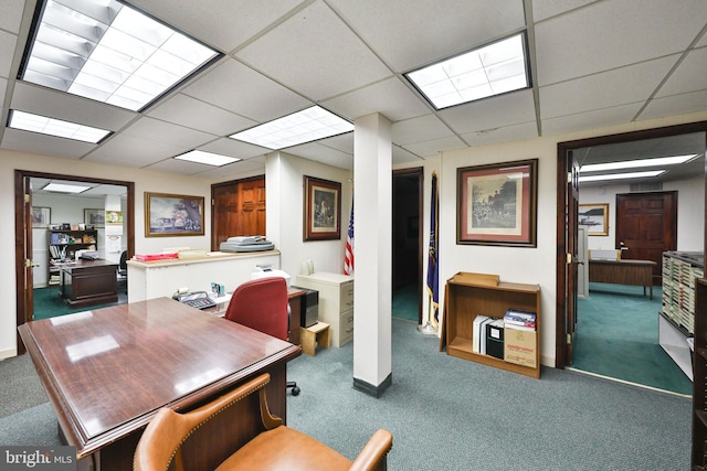 dining area with dark carpet and a drop ceiling