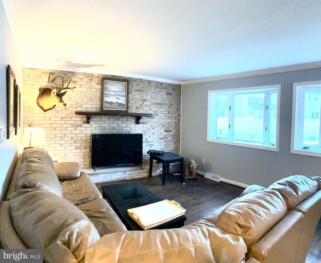 living room with brick wall, ornamental molding, a brick fireplace, and dark hardwood / wood-style floors