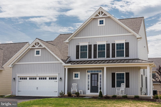 view of front facade with a front lawn, a porch, central AC, and a garage