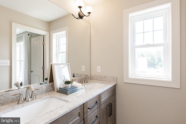 bathroom with double sink vanity and a chandelier