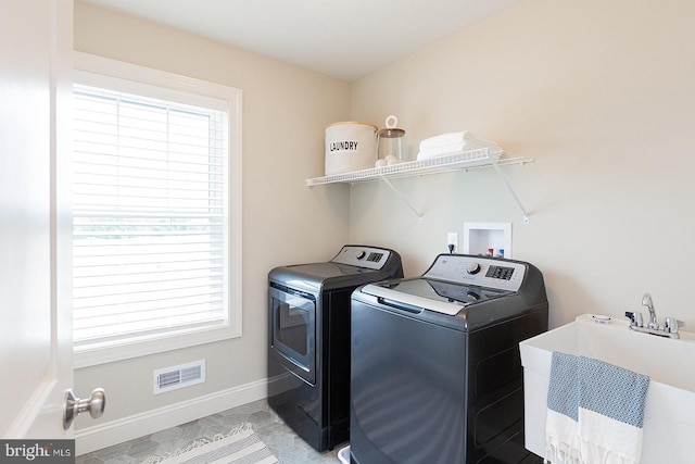 clothes washing area with washing machine and clothes dryer, sink, and hookup for a washing machine