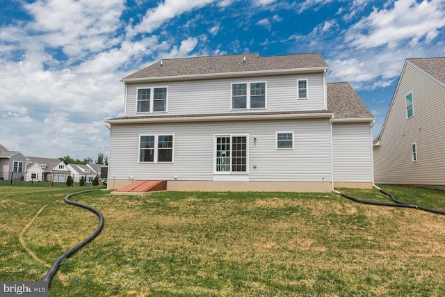 back of house with a lawn