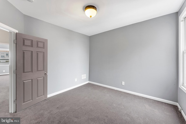 carpeted spare room featuring a healthy amount of sunlight